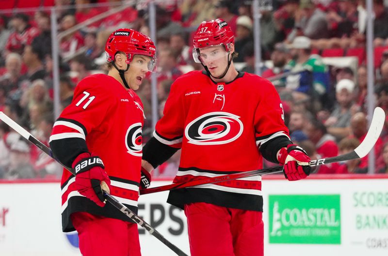 Apr 2, 2025; Raleigh, North Carolina, USA;  Carolina Hurricanes left wing Taylor Hall (71) and right wing Andrei Svechnikov (37) talk against the Washington Capitals during the first period at Lenovo Center. Mandatory Credit: James Guillory-Imagn Images
