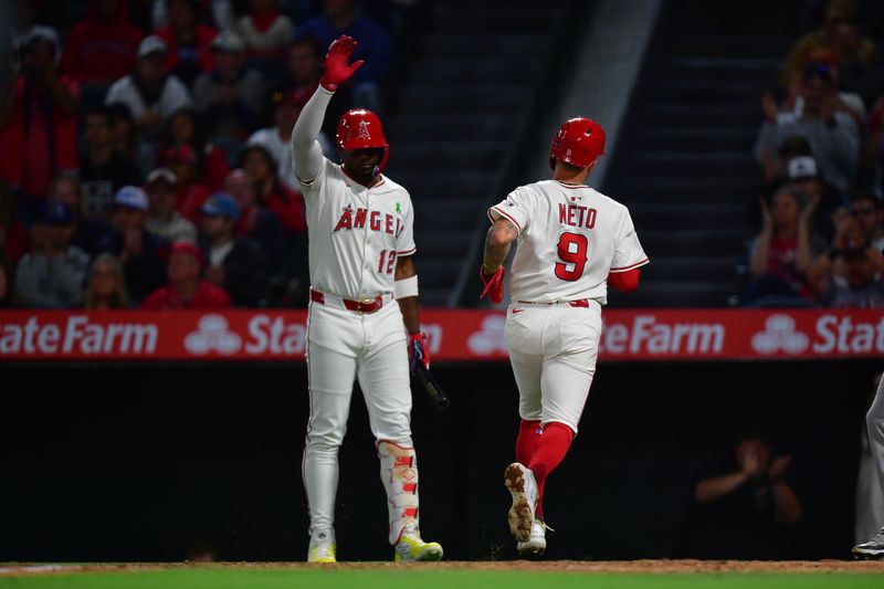 May 24, 2025; Anaheim, California, USA; Los Angeles Angels shortstop Zach Neto (9) is greeted by designated hitter Jorge Soler (12) after scoring a run against the Miami Marlins during the fourth inning  at Angel Stadium. Mandatory Credit: Gary A. Vasquez-Imagn Images