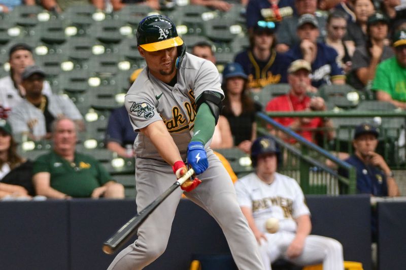 Jun 10, 2023; Milwaukee, Wisconsin, USA; Oakland Athletics shortstop Aledmys D  az (12) hit an RBI single against the Milwaukee Brewers in the tenth inning at American Family Field. Mandatory Credit: Benny Sieu-USA TODAY Sports