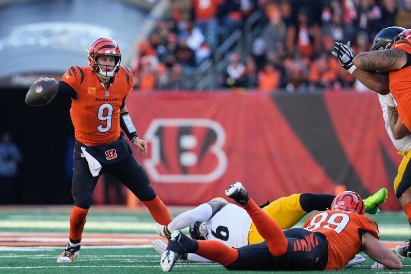 Cincinnati Bengals quarterback Joe Burrow (9) evades pressure from Pittsburgh Steelers linebacker Patrick Queen (6) during the first half of an NFL football game Sunday, Dec. 1, 2024, in Cincinnati. (AP Photo/Jeff Dean)