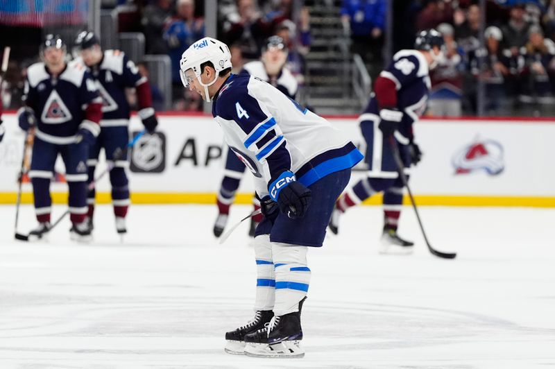 Dec 31, 2024; Denver, Colorado, USA; Winnipeg Jets defenseman Neal Pionk (4) reacts after the loss to the Colorado Avalanche at Ball Arena. Mandatory Credit: Ron Chenoy-Imagn Images