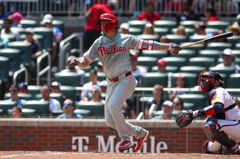 Jul 7, 2024; Atlanta, Georgia, USA; Philadelphia Phillies left fielder Whit Merrifield (9) hits a single against the Atlanta Braves in the seventh inning at Truist Park. Mandatory Credit: Brett Davis-USA TODAY Sports