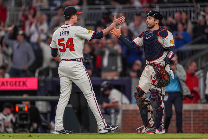 Apr 23, 2024; Cumberland, Georgia, USA; Atlanta Braves pitcher Max Fried (54) reacts with catcher Travis d'Arnaud (16) after pitching a complete game shutout against the Miami Marlins at Truist Park. Mandatory Credit: Dale Zanine-USA TODAY Sports