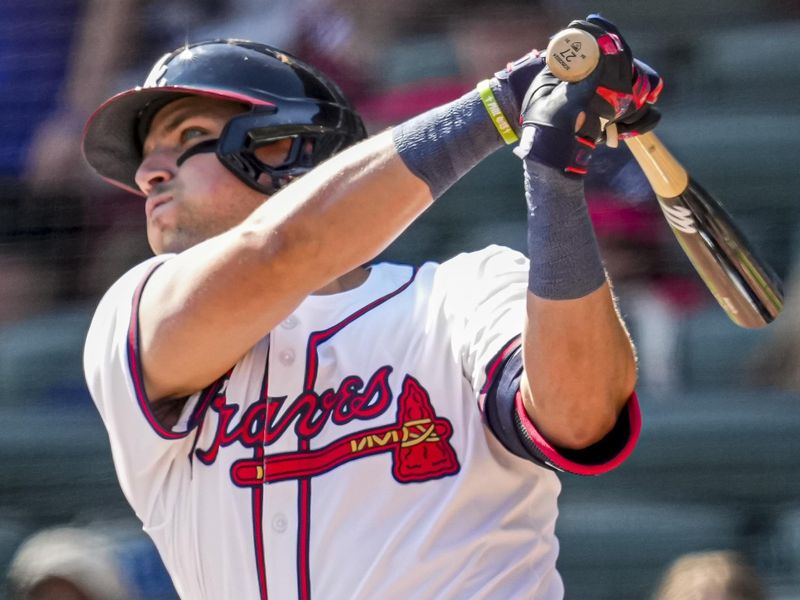 Apr 7, 2024; Cumberland, Georgia, USA; Atlanta Braves third baseman Austin Riley (27) hits a home run against the Arizona Diamondbacks during the eighth inning at Truist Park. Mandatory Credit: Dale Zanine-USA TODAY Sports