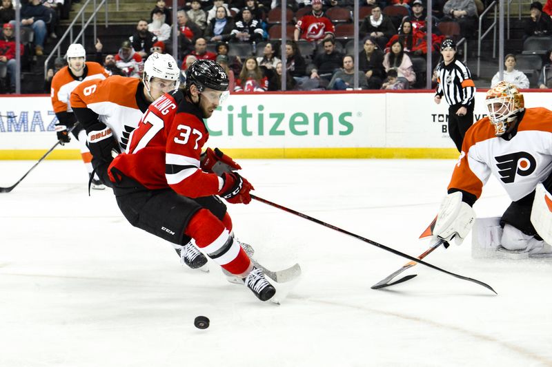 Jan 29, 2025; Newark, New Jersey, USA; New Jersey Devils center Justin Dowling (37) tries to gain control of the puck as Philadelphia Flyers defenseman Travis Sanheim (6) defends during the third period at Prudential Center. Mandatory Credit: John Jones-Imagn Images