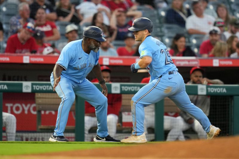 Aug 14, 2024; Anaheim, California, USA; Toronto Blue Jays left fielder Daulton Varsho (25) celebrates with third base coach Carlos Febles (51) after hitting a three-run home run in the fifth inning against the Los Angeles Angels at Angel Stadium. Mandatory Credit: Kirby Lee-USA TODAY Sports