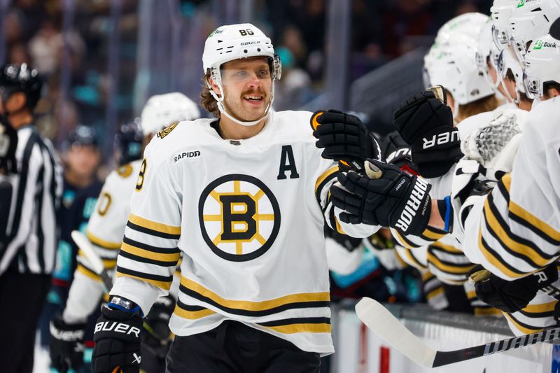 Feb 26, 2024; Seattle, Washington, USA; Boston Bruins right wing David Pastrnak (88) celebrates with teammates on the bench after scoring a goal against the Seattle Kraken during the first period at Climate Pledge Arena. Mandatory Credit: Joe Nicholson-USA TODAY Sports