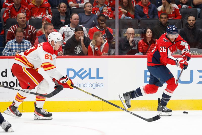 Oct 16, 2023; Washington, District of Columbia, USA; Washington Capitals right wing Nic Dowd (26) passes the puck as Calgary Flames center Adam Ruzicka (63) chases in the first period at Capital One Arena. Mandatory Credit: Geoff Burke-USA TODAY Sports