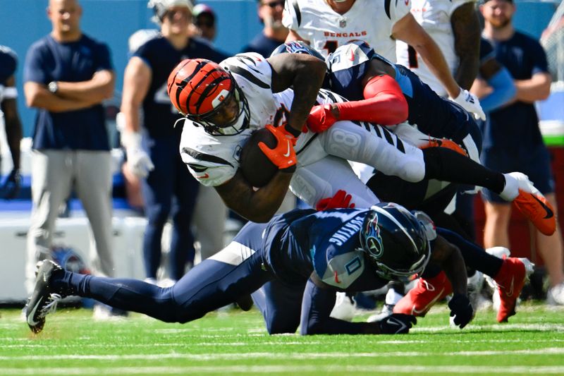 Cincinnati Bengals running back Joe Mixon (28) is tackled by Tennessee Titans cornerback Sean Murphy-Bunting, below, and safety Kevin Byard during an NFL football game Sunday, Sept. 30, 2023 in Nashville, Tenn. (AP Photo/John Amis)