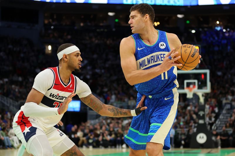 MILWAUKEE, WISCONSIN - NOVEMBER 24: Brook Lopez #11 of the Milwaukee Bucks is defended by Daniel Gafford #21 of the Washington Wizards during the second half of an In-Season Tournament game at Fiserv Forum on November 24, 2023 in Milwaukee, Wisconsin. NOTE TO USER: User expressly acknowledges and agrees that, by downloading and or using this photograph, User is consenting to the terms and conditions of the Getty Images License Agreement. (Photo by Stacy Revere/Getty Images)