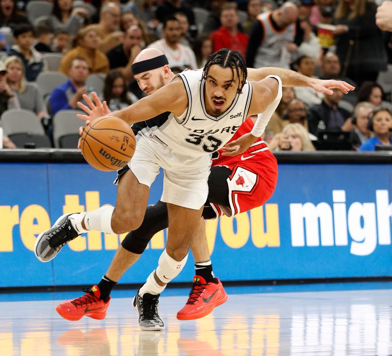 SAN ANTONIO, TX - JANUARY  13:  Tre Jones #33 of the San Antonio Spurs drives past Alex Caruso #6 of the Chicago Bulls in the second half at Frost Bank Center on January 13, 2024 in San Antonio, Texas. NOTE TO USER: User expressly acknowledges and agrees that, by downloading and or using this photograph, User is consenting to terms and conditions of the Getty Images License Agreement. (Photo by Ronald Cortes/Getty Images)