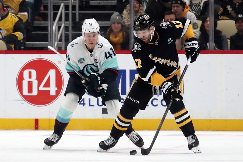 Jan 14, 2025; Pittsburgh, Pennsylvania, USA;  Pittsburgh Penguins right wing Bryan Rust (17) handles the puck against Seattle Kraken defenseman Ryker Evans (41) second period at PPG Paints Arena. Mandatory Credit: Charles LeClaire-Imagn Images