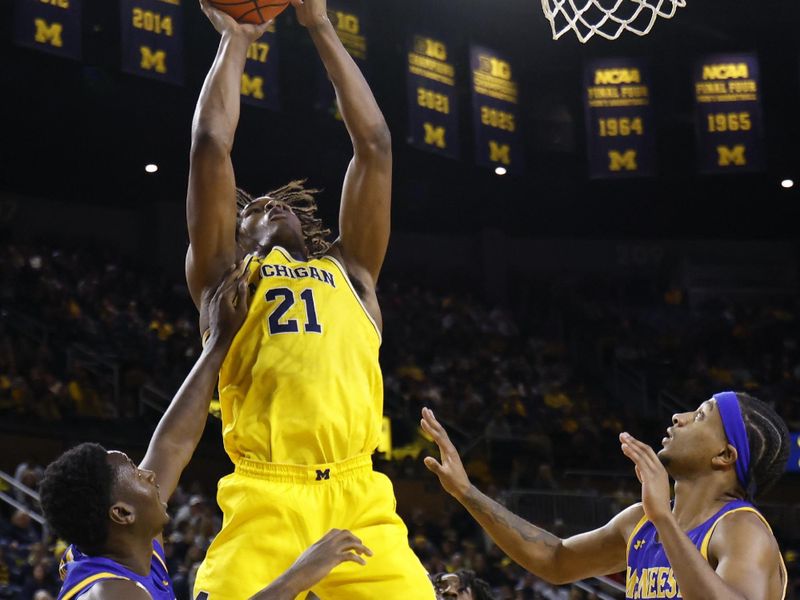 Dec 29, 2025; Ann Arbor, Michigan, USA;  Michigan Wolverines forward Morez Johnson Jr. (21) shoots on McNeese Cowboys guard DJ Richards Jr. (2) in the first half at Crisler Center. Mandatory Credit: Rick Osentoski-Imagn Images