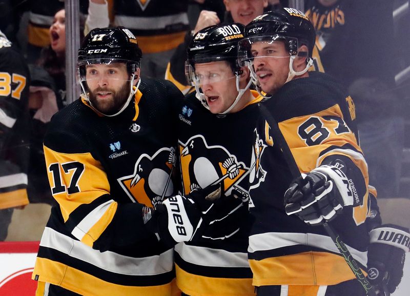 Jan 27, 2024; Pittsburgh, Pennsylvania, USA;  Pittsburgh Penguins left wing Jake Guentzel (middle) celebrates with right wing Bryan Rust (17) and center Sidney Crosby (87) after Guentzel scored a goal against the Montreal Canadiens during the third period at PPG Paints Arena. The Penguins won 3-2 in overtime. Mandatory Credit: Charles LeClaire-USA TODAY Sports