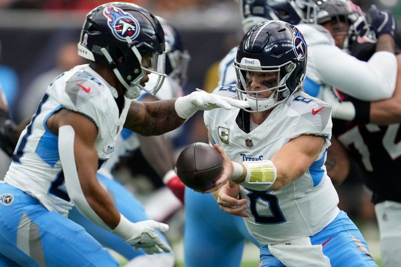 Tennessee Titans quarterback Will Levis, right, hands the ball to running back Tony Pollard, left, during the first half of an NFL football game against the Houston Texans, Sunday, Nov. 24, 2024, in Houston. (AP Photo/Ashley Landis)