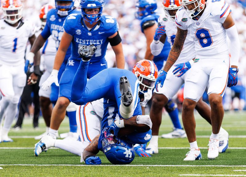 Sep 30, 2023; Lexington, Kentucky, USA; Kentucky Wildcats running back Ray Davis (1) is knocked off his feet by Florida Gators linebacker Scooby Williams (17) during the third quarter at Kroger Field. Mandatory Credit: Jordan Prather-USA TODAY Sports