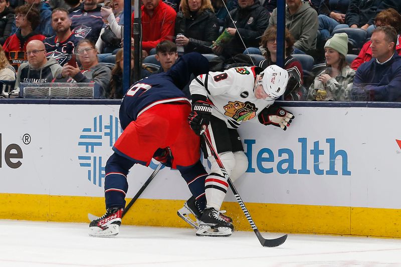 Nov 22, 2023; Columbus, Ohio, USA; Columbus Blue Jackets defenseman Ivan Provorov (9) and Chicago Blackhawks center Ryan Donato (8) battle for the puck during the second period at Nationwide Arena. Mandatory Credit: Russell LaBounty-USA TODAY Sports