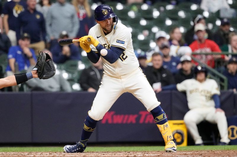 Apr 29, 2024; Milwaukee, Wisconsin, USA;  Milwaukee Brewers  pitch hitter Rhys Hoskins (12) is hit by a pitch during the ninth inning against the Tampa Bay Rays at American Family Field. Mandatory Credit: Jeff Hanisch-USA TODAY Sports