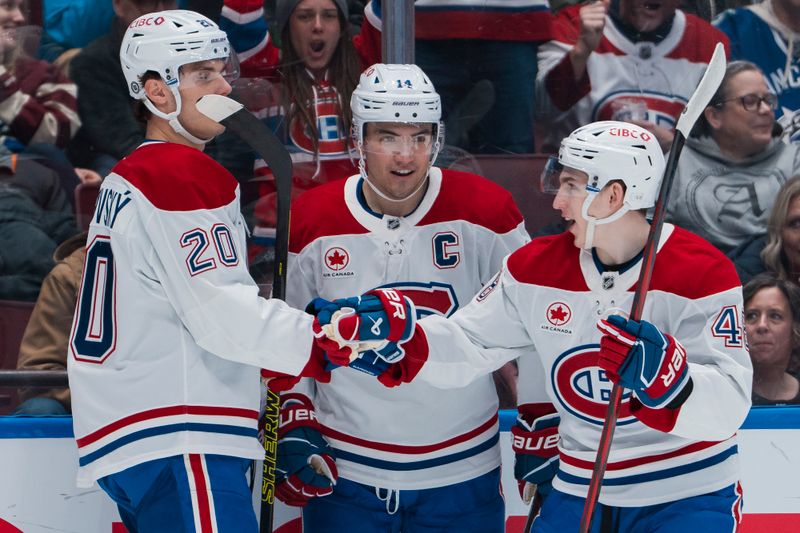 Mar 11, 2025; Vancouver, British Columbia, CAN; Montreal Canadiens forward Juraj Slafkovský (20) and forward Nick Suzuki (14) and defenseman Lane Hutson (48) celebrate Slafkovský’s goal against the Vancouver Canucks  in the first period at Rogers Arena. Mandatory Credit: Bob Frid-Imagn Images