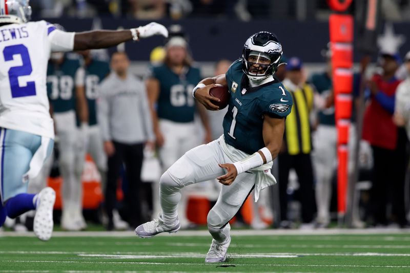 Philadelphia Eagles quarterback Jalen Hurts (1) carries the ball for a long gain as Dallas Cowboys' Jourdan Lewis (2) attempts to make the stop in the first half of an NFL football game in Arlington, Texas, Sunday, Nov. 10, 2024. (AP Photo/Gareth Patterson)