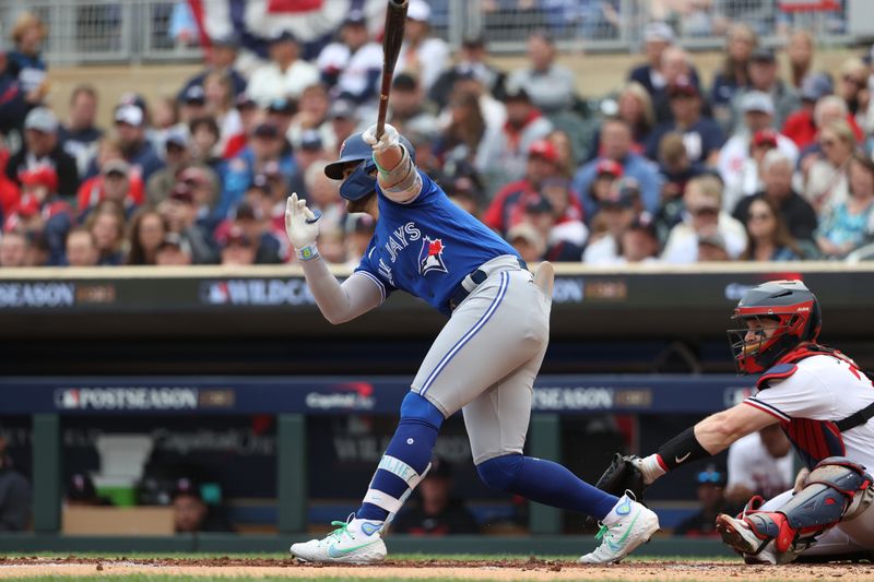 Oct 4, 2023; Minneapolis, Minnesota, USA; Toronto Blue Jays shortstop Bo Bichette (11) hits a single in the third inning against the Minnesota Twins during game two of the Wildcard series for the 2023 MLB playoffs at Target Field. Mandatory Credit: Jesse Johnson-USA TODAY Sports