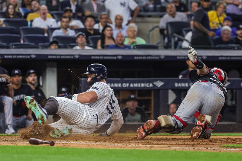 Jun 5, 2024; Bronx, New York, USA; New York Yankees center fielder Aaron Judge (99) slides safely past Minnesota Twins catcher Ryan Jeffers (27) for a run during the fifth inning at Yankee Stadium. Mandatory Credit: Vincent Carchietta-USA TODAY Sports