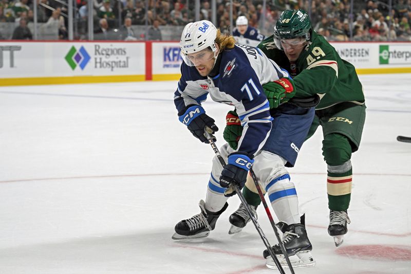 Sep 27, 2024; Saint Paul, Minnesota, USA;  Minnesota Wild defenseman Jack Peart (49) defends against Winnipeg Jets forward Axel Jonsson-Fjallby (71) during the first period at Xcel Energy Center. Mandatory Credit: Nick Wosika-Imagn Images

