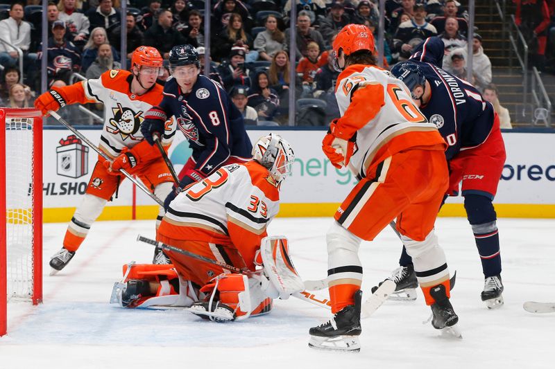 Dec 16, 2025; Columbus, Ohio, USA; Anaheim Ducks goalie Ville Husso (33) makes a save as Columbus Blue Jackets defenseman Zach Werenski (8) looks for a rebound during the second period at Nationwide Arena. Mandatory Credit: Russell LaBounty-Imagn Images