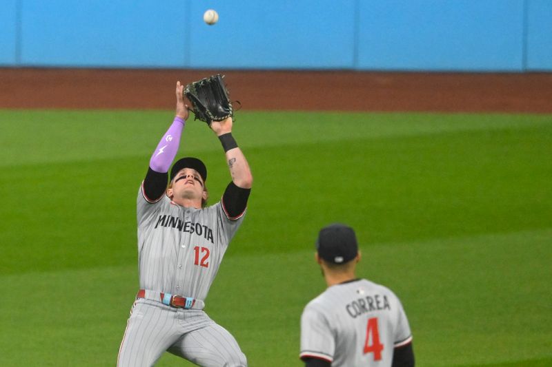 Apr 29, 2025; Cleveland, Ohio, USA; Minnesota Twins left fielder Harrison Bader (12) makes a catch beside shortstop Carlos Correa (4) in the first inning against the Cleveland Guardians at Progressive Field. Mandatory Credit: David Richard-Imagn Images