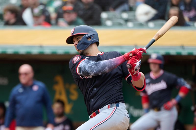 Apr 14, 2024; Oakland, California, USA; Washington Nationals first baseman Joey Meneses (45) hits an RBI single against the Oakland Athletics during the third inning at Oakland-Alameda County Coliseum. Mandatory Credit: Robert Edwards-USA TODAY Sports