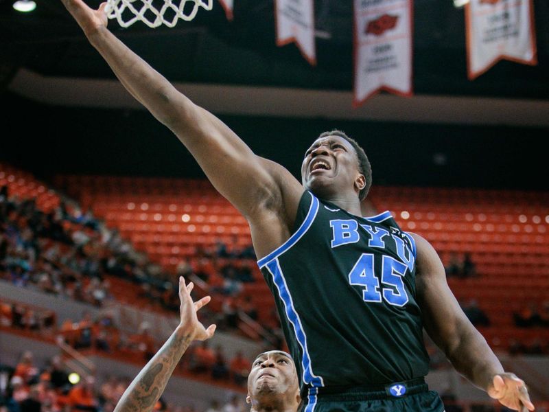 Feb 17, 2024; Stillwater, Oklahoma, USA; Brigham Young Cougars forward Fousseyni Traore (45) shoots the ball over Oklahoma State Cowboys center Brandon Garrison (23) during the second half at Gallagher-Iba Arena. Mandatory Credit: William Purnell-USA TODAY Sports