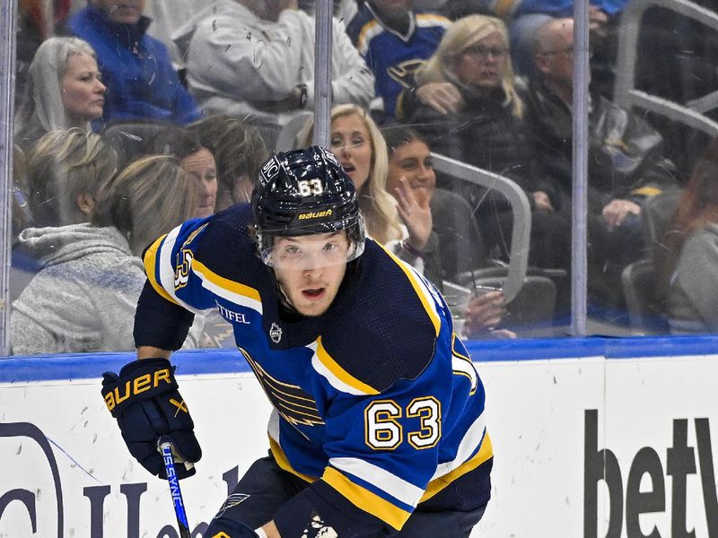 Nov 9, 2023; St. Louis, Missouri, USA;  St. Louis Blues left wing Jake Neighbours (63) controls the puck against the Arizona Coyotes during the second period at Enterprise Center. Mandatory Credit: Jeff Curry-USA TODAY Sports