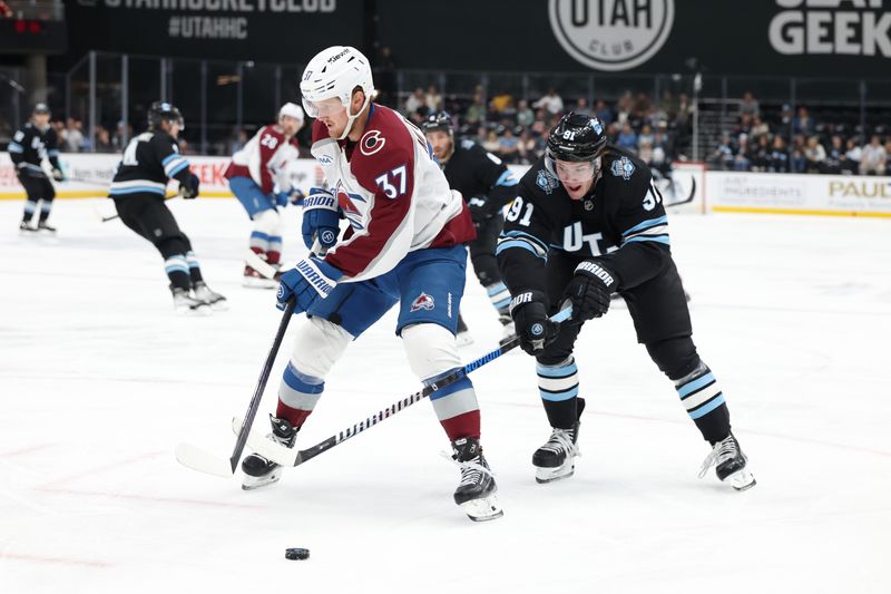 Oct 24, 2024; Salt Lake City, Utah, USA; Colorado Avalanche center Casey Mittelstadt (37) and Utah Hockey Club right wing Josh Doan (91) battle for the puck during the second period at Delta Center. Mandatory Credit: Rob Gray-Imagn Images