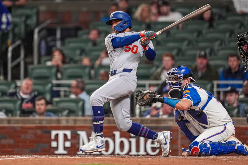 May 3, 2025; Cumberland, Georgia, USA; Los Angeles Dodgers shortstop Mookie Betts (50) hits a double to drive in a run against the Atlanta Braves during the fourth inning at Truist Park. Mandatory Credit: Dale Zanine-Imagn Images