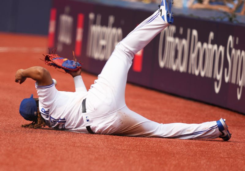 Jul 16, 2023; Toronto, Ontario, CAN; Toronto Blue Jays first baseman Vladimir Guerrero Jr. (27) is unable to catch a foul ball against the Arizona Diamondbacks during the ninth inning at Rogers Centre. Mandatory Credit: Nick Turchiaro-USA TODAY Sports