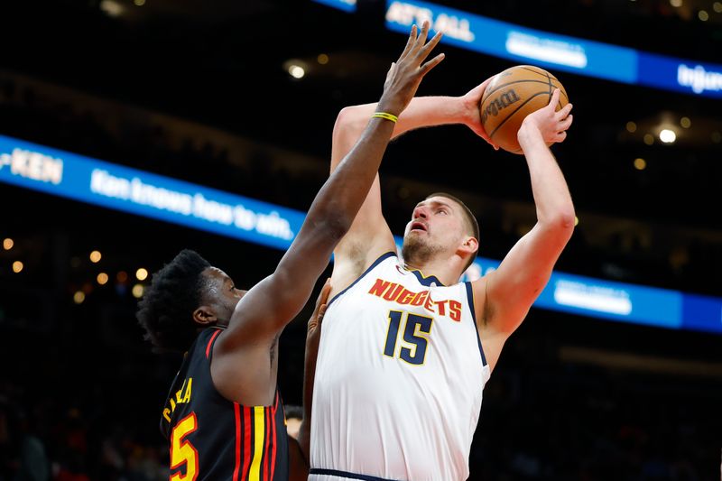 ATLANTA, GEORGIA - DECEMBER 08: Nikola Jokic #15 of the Denver Nuggets goes up for a shot over Clint Capela #15 of the Atlanta Hawks during the first quarter at State Farm Arena on December 8, 2024 in Atlanta, Georgia. NOTE TO USER: User expressly acknowledges and agrees that, by downloading and or using this photograph, User is consenting to the terms and conditions of the Getty Images License Agreement. (Photo by Todd Kirkland/Getty Images)