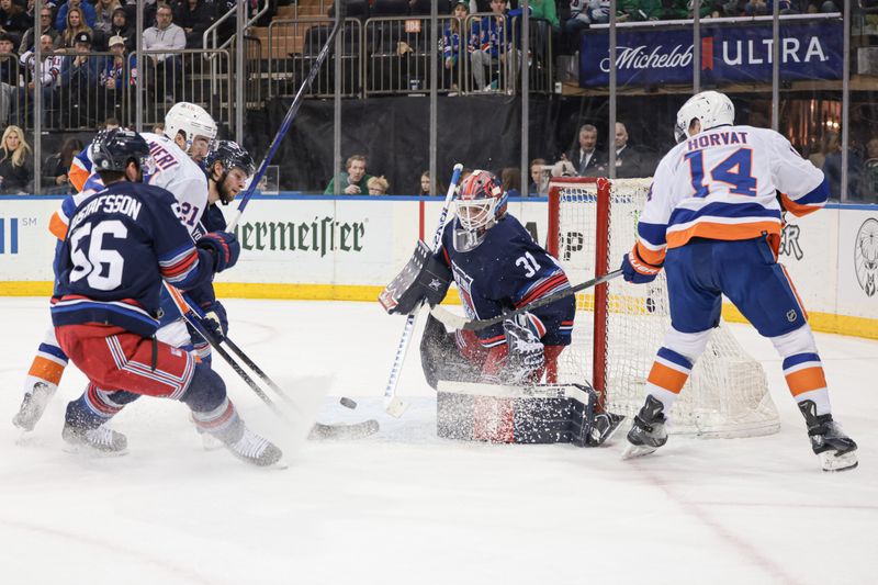 Mar 17, 2024; New York, New York, USA; New York Rangers goaltender Igor Shesterkin (31) makes a save againstNew York Islanders center Bo Horvat (14) in front of defenseman Erik Gustafsson (56) during the first period at Madison Square Garden. Mandatory Credit: Vincent Carchietta-USA TODAY Sports