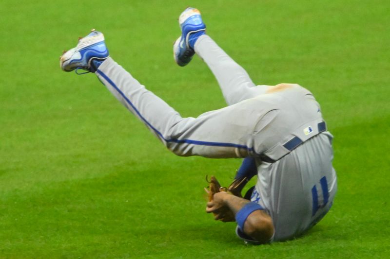 Aug 27, 2024; Cleveland, Ohio, USA; Kansas City Royals second baseman Maikel Garcia (11) tumbles after making a catch in the sixth inning against the Cleveland Guardians at Progressive Field. Mandatory Credit: David Richard-USA TODAY Sports