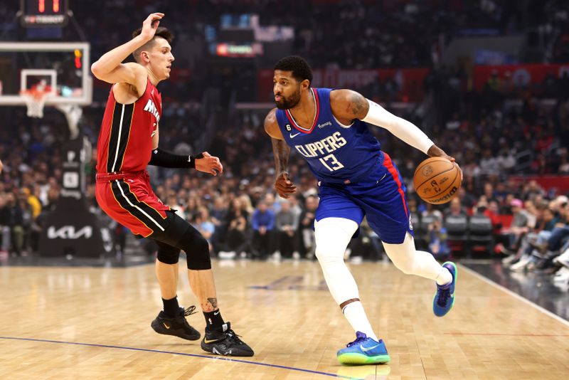 LOS ANGELES, CALIFORNIA - JANUARY 02: Paul George #13 of the Los Angeles Clippers drives to the basket against Tyler Herro #14 of the Miami Heat during the first quarter at Crypto.com Arena on January 02, 2023 in Los Angeles, California. NOTE TO USER: User expressly acknowledges and agrees that, by downloading and or using this photograph, User is consenting to the terms and conditions of the Getty Images License Agreement. (Photo by Katelyn Mulcahy/Getty Images)