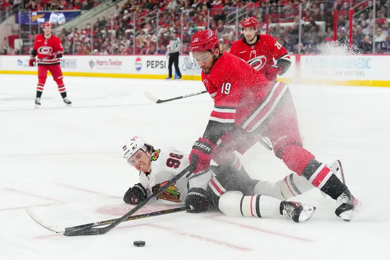 Jan 22, 2026; Raleigh, North Carolina, USA;  Carolina Hurricanes defenseman K'andre Miller (19) checks Chicago Blackhawks center Connor Bedard (98) during the second period at Lenovo Center. Mandatory Credit: James Guillory-Imagn Images