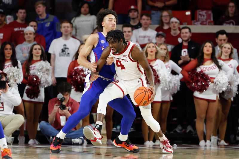 Feb 11, 2023; Norman, Oklahoma, USA; Oklahoma Sooners guard Joe Bamisile (4) drives against Kansas Jayhawks forward Jalen Wilson (10) during the first half at Lloyd Noble Center. Mandatory Credit: Alonzo Adams-USA TODAY Sports