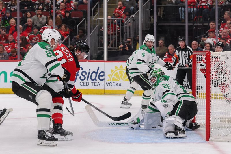 Dec 3, 2025; Newark, New Jersey, USA; Dallas Stars goaltender Jake Oettinger (29) makes a save on New Jersey Devils center Dawson Mercer (91) during the second period at Prudential Center. Mandatory Credit: Ed Mulholland-Imagn Images