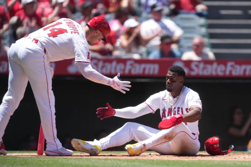 May 11, 2025; Anaheim, California, USA; Los Angeles Angels designated hitter Jorge Soler (12) is congratulated by catcher Logan O'Hoppe (14) after scoring in the first inning against the Baltimore Orioles at Angel Stadium. Mandatory Credit: Kirby Lee-Imagn Images