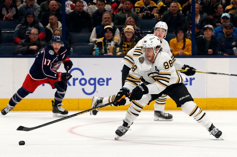 Jan 2, 2024; Columbus, Ohio, USA; Boston Bruins right wing David Pastrnak (88) reaches for the loose puck against the Columbus Blue Jackets during the second period at Nationwide Arena. Mandatory Credit: Russell LaBounty-USA TODAY Sports