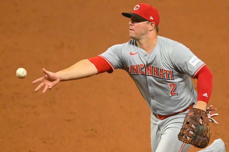 Sep 24, 2024; Cleveland, Ohio, USA; Cincinnati Reds first baseman Ty France (2) tosses the ball to first base in the sixth inning against the Cleveland Guardians at Progressive Field. Mandatory Credit: David Richard-Imagn Images