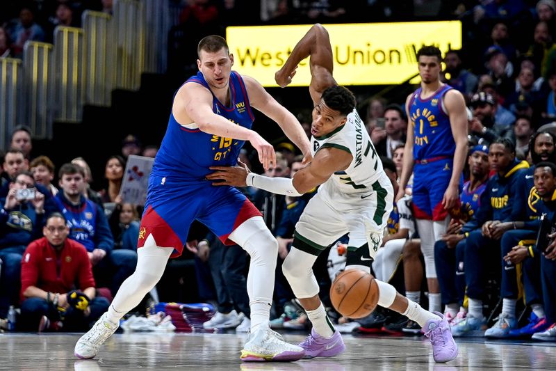 DENVER, CO - MARCH 25:  Giannis Antetokounmpo #34 of the Milwaukee Bucks steals the ball from Nikola Jokic #15 of the Denver Nuggets in the second half of a game at Ball Arena on March 25, 2023 in Denver, Colorado. NOTE TO USER: User expressly acknowledges and agrees that, by downloading and or using this photograph, User is consenting to the terms and conditions of the Getty Images License Agreement. (Photo by Dustin Bradford/Getty Images)