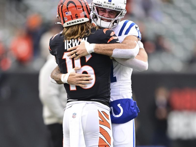 Cincinnati Bengals wide receiver Trenton Irwin (16) hugs Indianapolis Colts wide receiver Michael Pittman Jr. (11) during warm ups before an NFL football game on Sunday, Dec. 10, 2023, in Cincinnati. (AP Photo/Emilee Chinn)