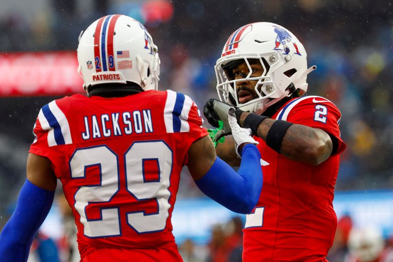 New England Patriots cornerback J.C. Jackson (29) and cornerback Jalen Mills (2) celebrate after a stop during the first half of an NFL football game against the Los Angeles Chargers on Sunday, Dec. 3, 2023, in Foxborough, Mass. (AP Photo/Greg M. Cooper)