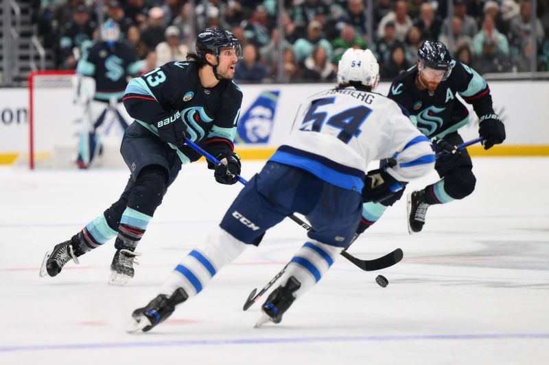 Mar 8, 2024; Seattle, Washington, USA; Seattle Kraken left wing Brandon Tanev (13) advances the puck against the Winnipeg Jets during the second period at Climate Pledge Arena. Mandatory Credit: Steven Bisig-USA TODAY Sports