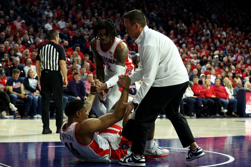 Jan 4, 2024; Tucson, Arizona, USA; Arizona Wildcats forward Keshad Johnson (16) gets helped up by Arizona Wildcats guard Caleb Love (2) and Athletic Trainer Justin Kokoskie (right) during the first half at McKale Center. Mandatory Credit: Zachary BonDurant-USA TODAY Sports